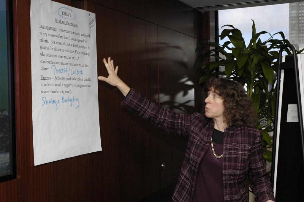 Bonnie Koenig gesturing at a page from a flipchart a list of
