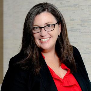 Headshot of Kathleen Enright, president and CEO, Council on Foundations, in a red shirt and black jacket.