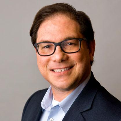 Chris Crothers, Director of Impact Investing at the Jessie Ball duPont Fund, in glasses and a navy suit jacket.