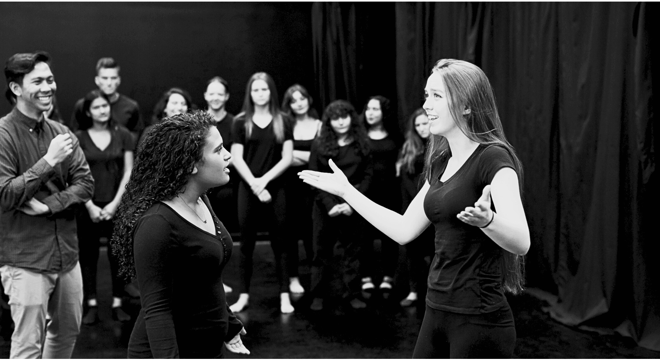 A group of actors rehearsing on a stage.