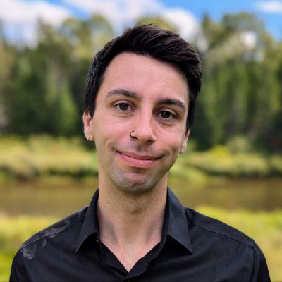 Headshot of Edward Moore, data analyst a GivingTuesday, in a black shirt standing outdoors.