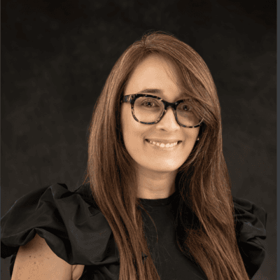 Headshot of Joan Marie Godoy, CEO of Radial Partners, in a black top.
