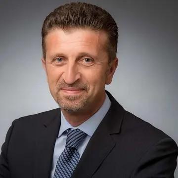 Headshot of Aleksander Dardeli, COO of Save the Children US.