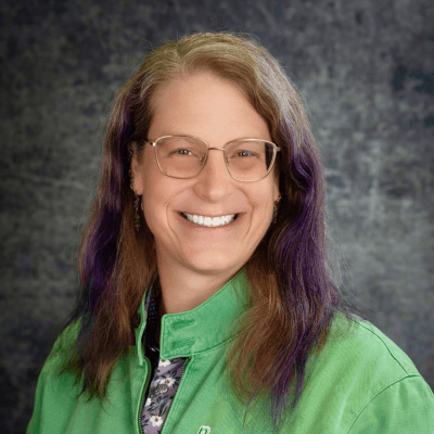 Headshot of Tracy Kronzak, Chief Strategy Officer, Benevolent Tech, in a green top.