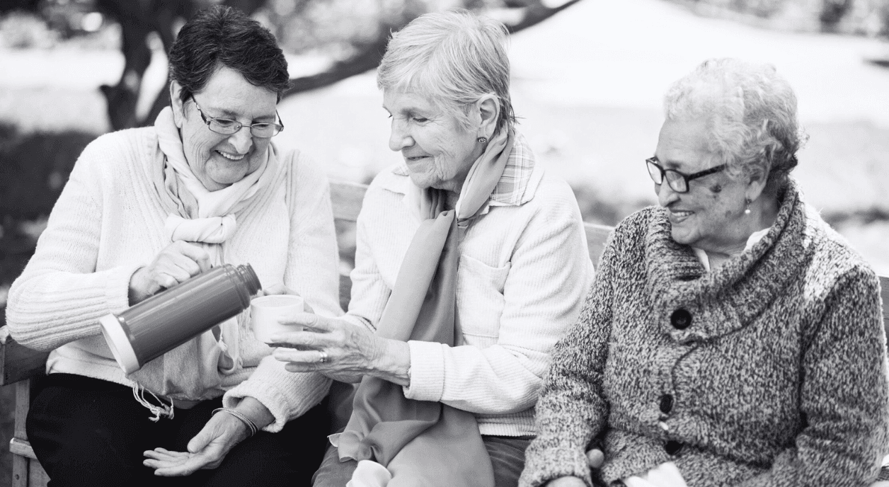 Three older women drinking coffee together.