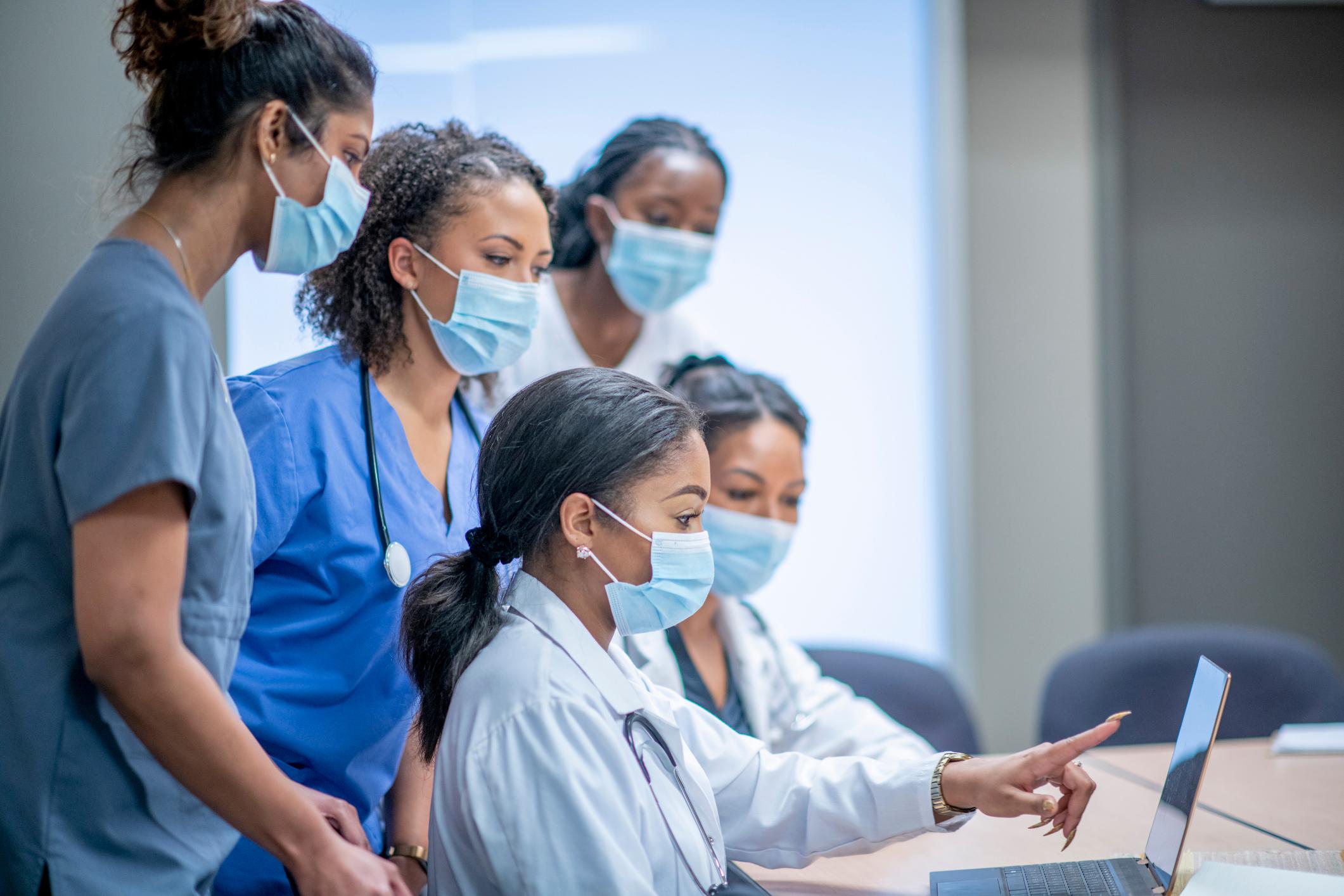 A diverse group of doctors and nurses discuss medical data.