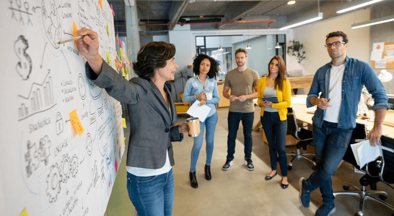 A woman explaining potential fundraising strategies to her team.