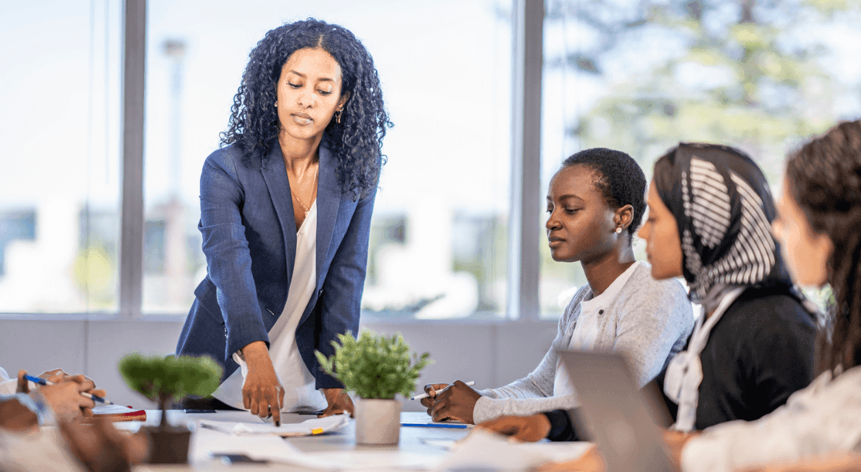 A woman leader putting on a brave face in front of her diverse team.