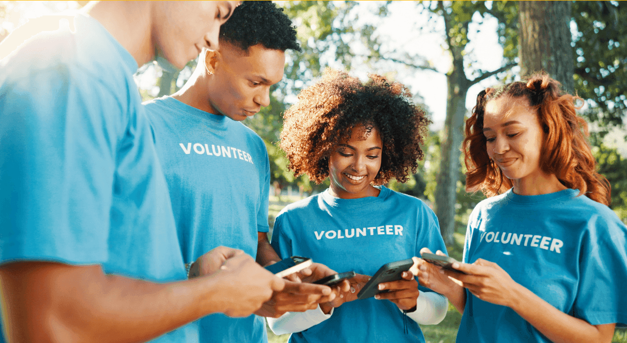 A group of young volunteers looking at their devices.