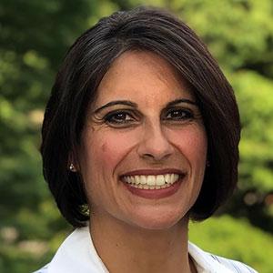 Ofira Bondorowsky, a woman with short, dark hair, smiles at the camera