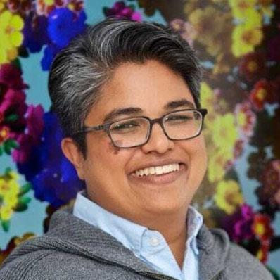 Rini Chakraborty Vice President of Four Freedoms Fund, NEO Philanthropy, in glasses and a gray sweater.