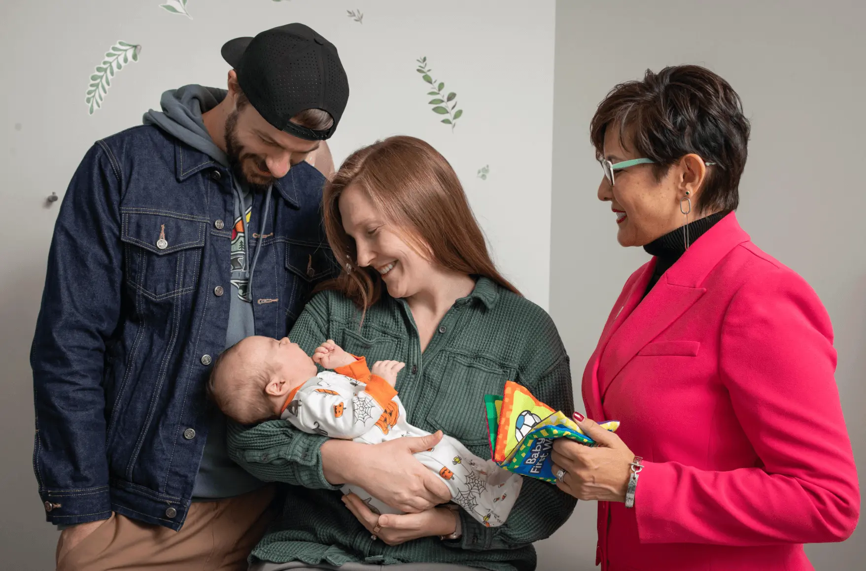 Parents holding a baby with the author, Dr. Lynette Fraga, next to them.