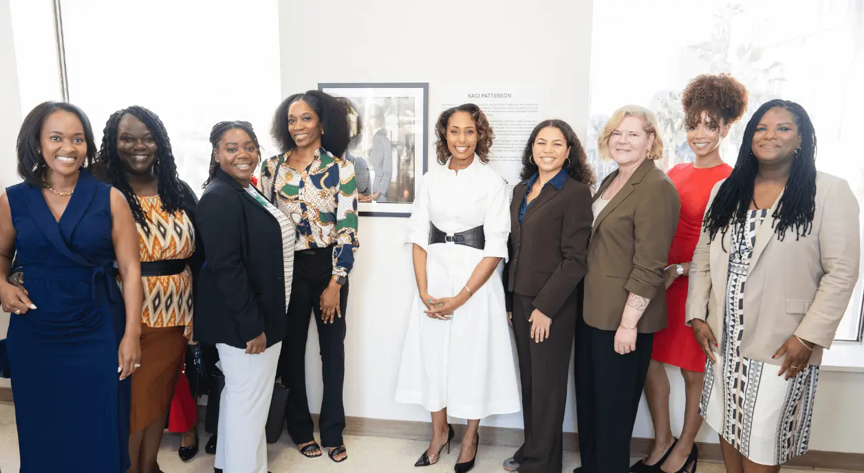 Author Kaci Patterson stands in the middle of a row of nine women leaders.