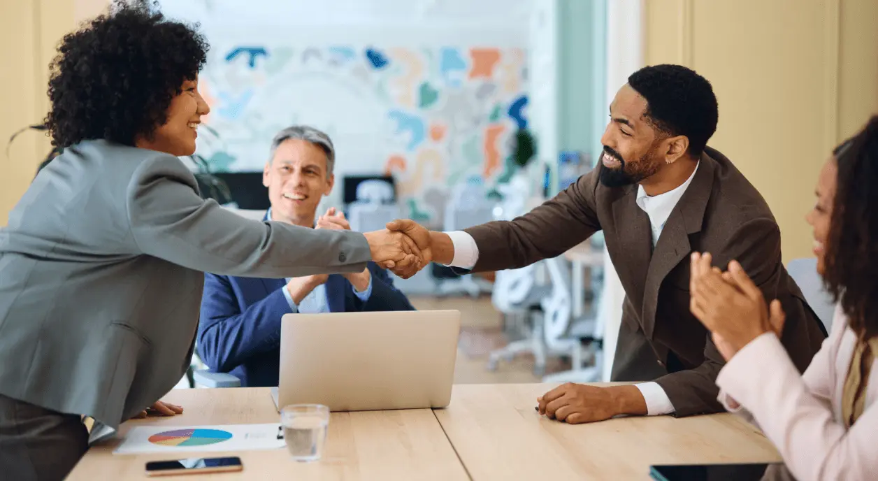 Colleagues shaking hands during a meeting.