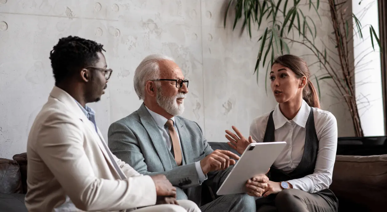 Three people sitting and discussing in an office.