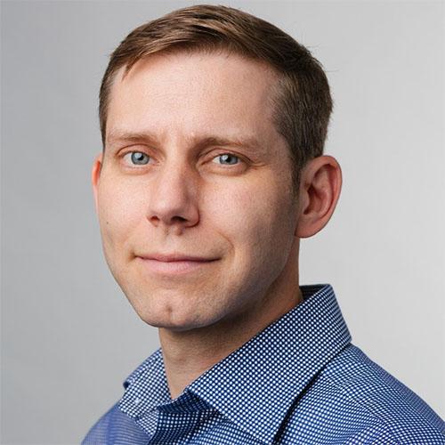 Headshot of Chris Maddocks, Senior Vice President, Creative Strategy, Blue State, in a blue shirt.